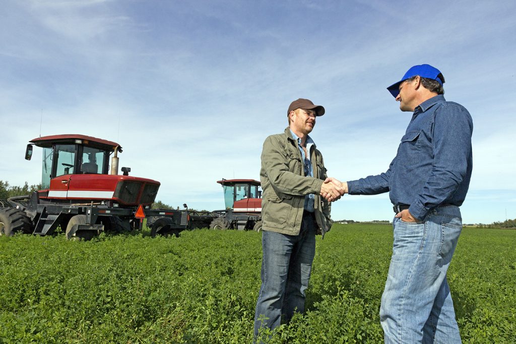 Farmers Handshake at a Farm with Tractors
